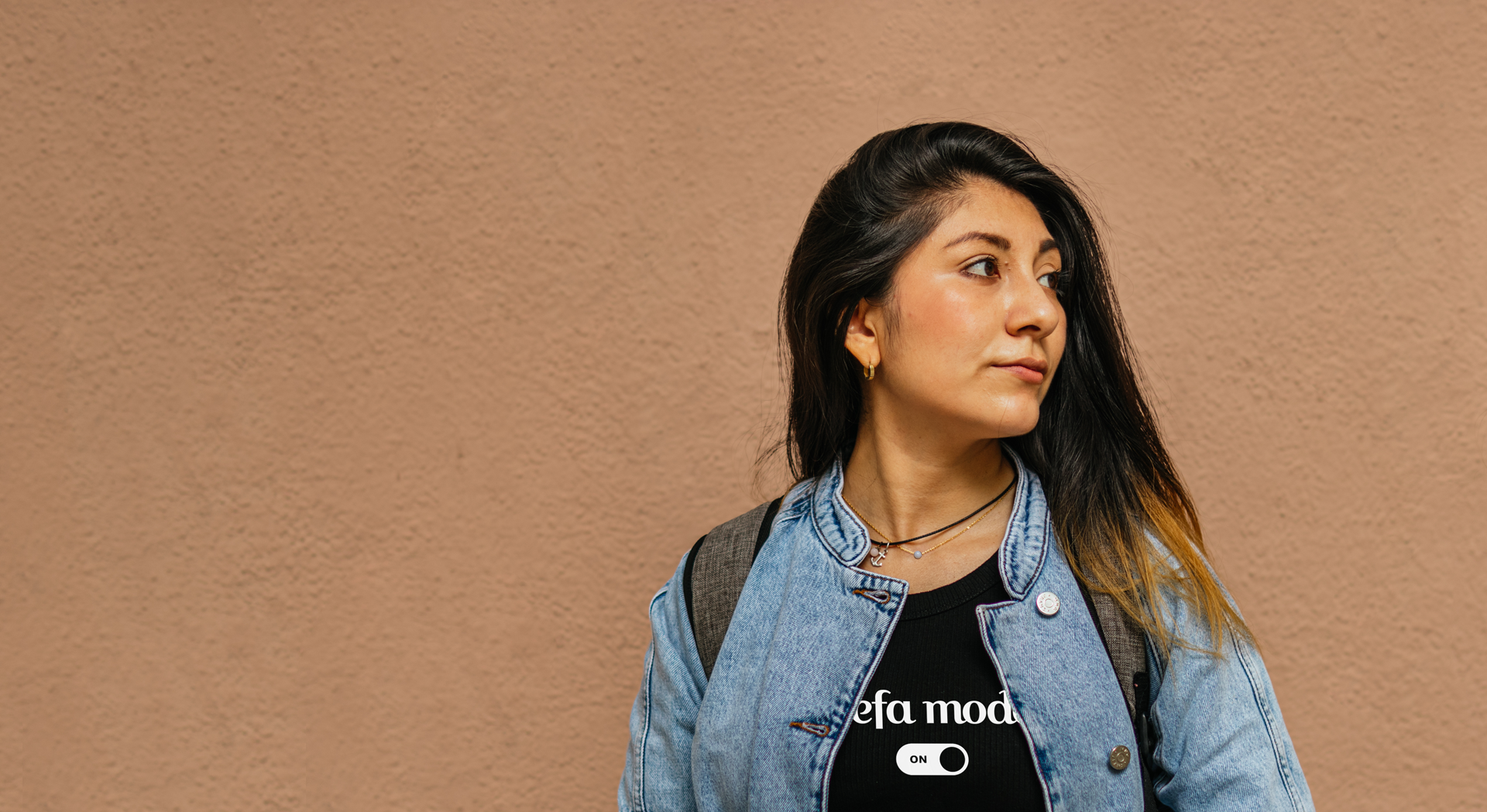 Woman wearing a denim jacket with 'Jefa mode' branding against a beige background